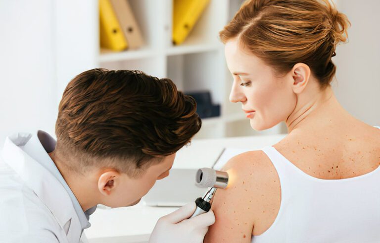 Arzt untersucht die Haut einer Patientin mit dem Dermatoskop